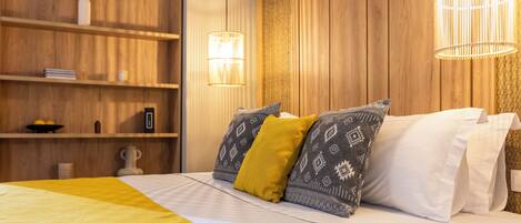 Un dormitorio ordenado con cama, estanterías y una lámpara colgante.