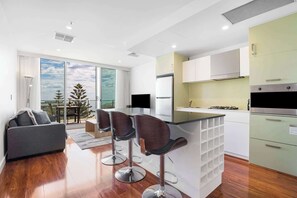 Una cucina moderna con isola centrale, sgabelli da bar e zona pranzo con vista.