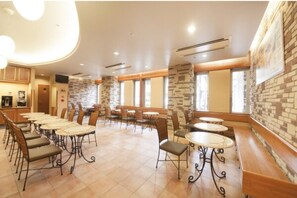 Enjoy meals in this spacious dining area with long communal tables and smaller round tables.