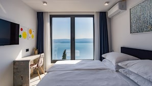 Una habitación de hotel moderna con una cama grande, un escritorio y un televisor.