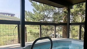 A hot tub on a wooden deck with a view of a ski lift and trees. - Remodeled 1-Bdrm Ski-In/-Out Condo w/ Fireplace! (Steamboat Springs)