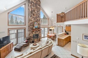 Flatskjerm-TV, peis, bøker og kontorer