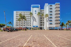 Un hôtel à plusieurs étages, reconnaissable à son grand panneau indiquant le chiffre « 250 », agrémenté de palmiers et doté d’un parking.