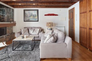 A living room with a fireplace, two sofas, a coffee table, and a rug. - Val de Ruda Luxe 66 by FeelFree Rentals (Naut Aran)