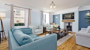 A modern living room with a sofa set, a coffee table, and a fireplace. - Clovelly House: Relaxed Family Coastal Home (Berwick-upon-Tweed)