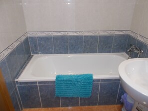 Een bad, een bidet, handdoeken, zeep