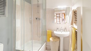 Et badeværelse med bruseniche, håndvask og toilet.