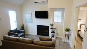 A living room with a fireplace, a television, and a sofa.
