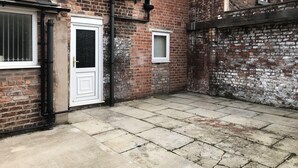 A brick building with a white door and a small window. - Modern Comfy 2-bedroom Flat in St Helens (St Helens)