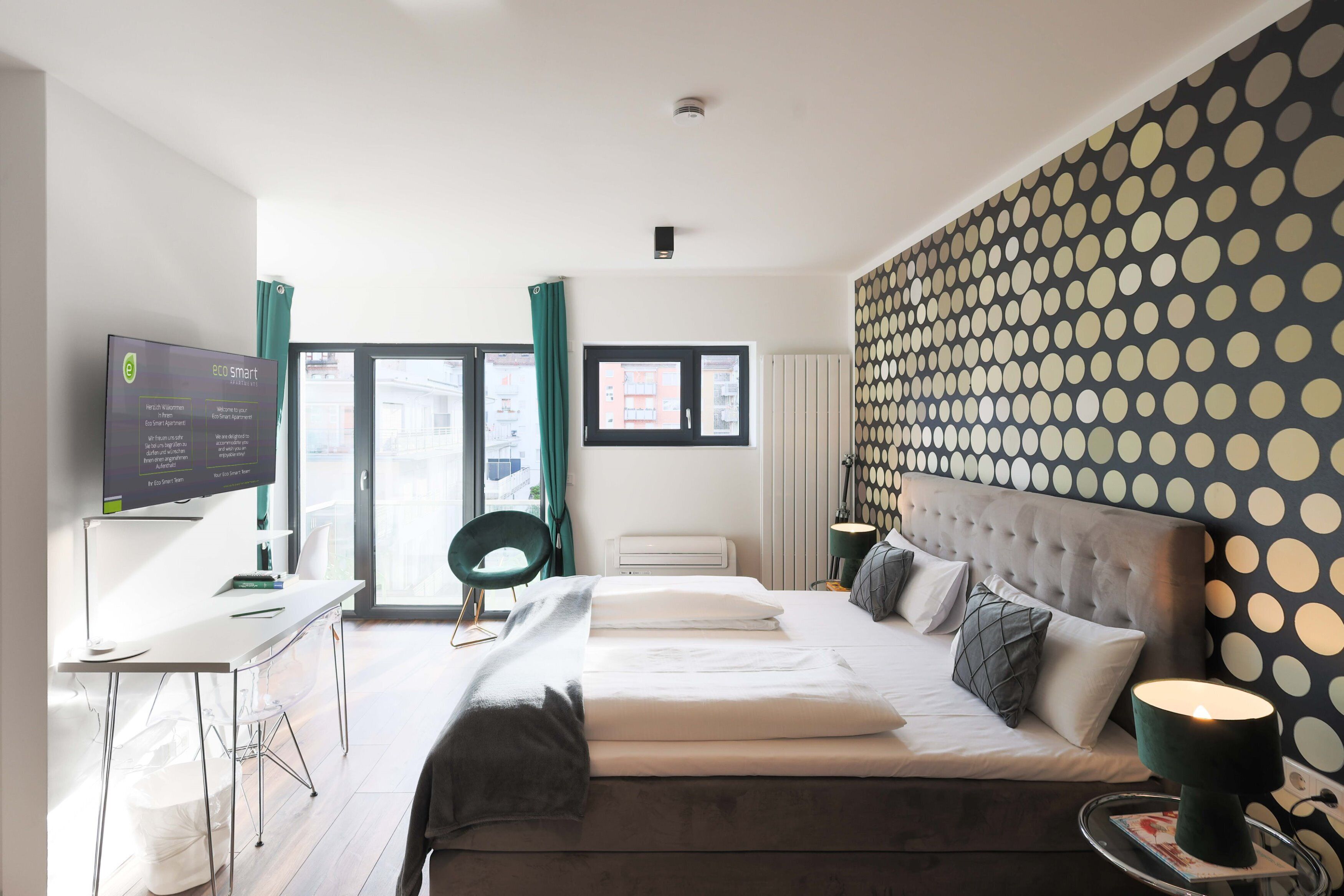 Una habitación de hotel moderna con cama, escritorio y televisión.
