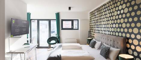 Una habitación de hotel moderna con cama, escritorio y televisión.