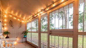 A covered outdoor area with string lights, a table, chairs, and potted plants. - Brandon Peaceful Home w/newly renovated kitchen (Brandon)