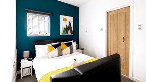 A neatly arranged bedroom with a bed, bedside table, and a nightstand.