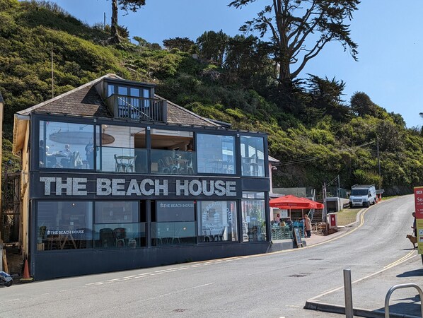 A two-story building with a sign reading "The Beach House."