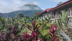 Un edificio con tejado rojo y un jardín al frente.
