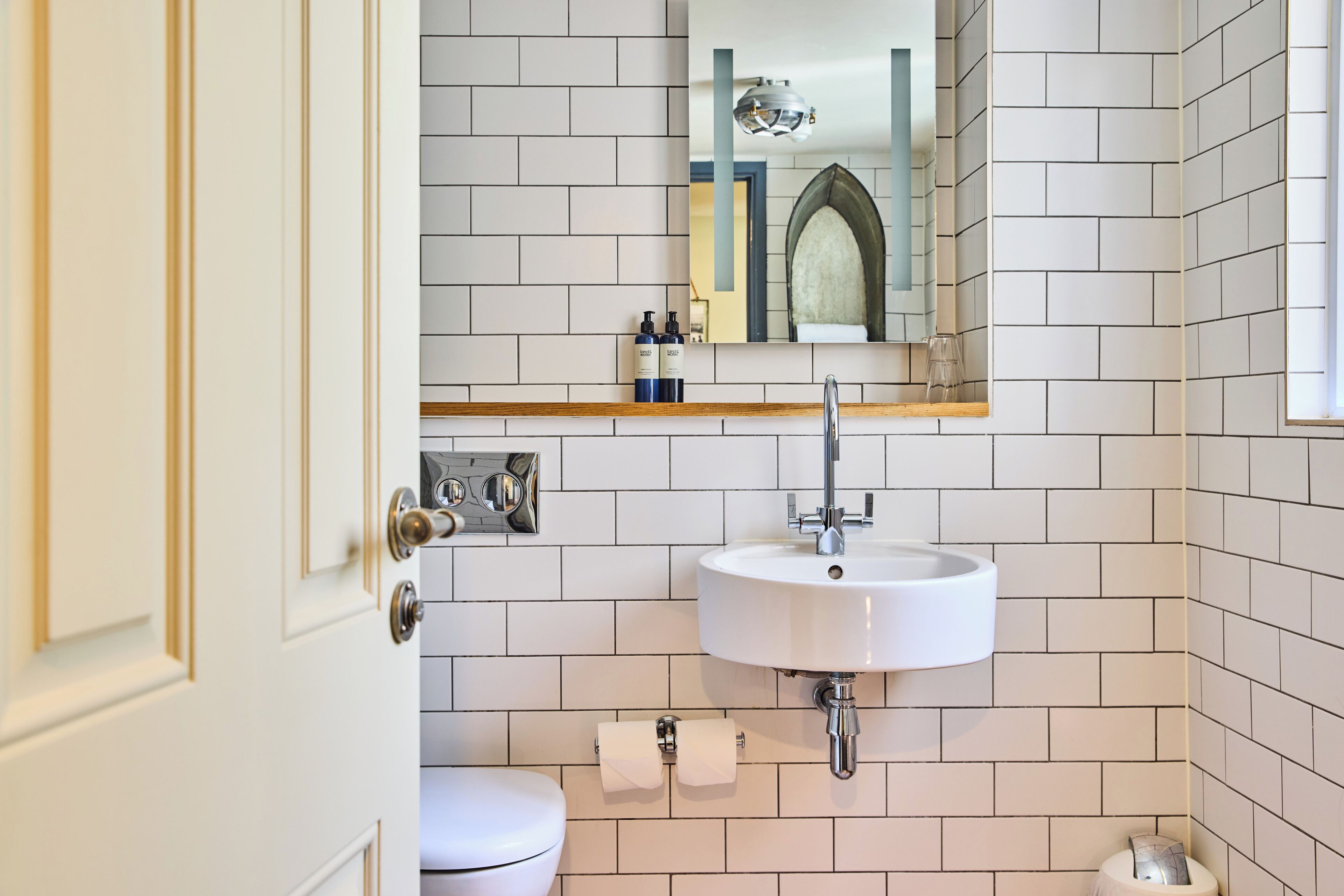 A bathroom with a white sink, a toilet, and a mirror above the sink.