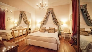 A luxurious bedroom with a large bed, two bedside tables, a chandelier, and draped curtains. - Duchessa Margherita (Vicoforte)