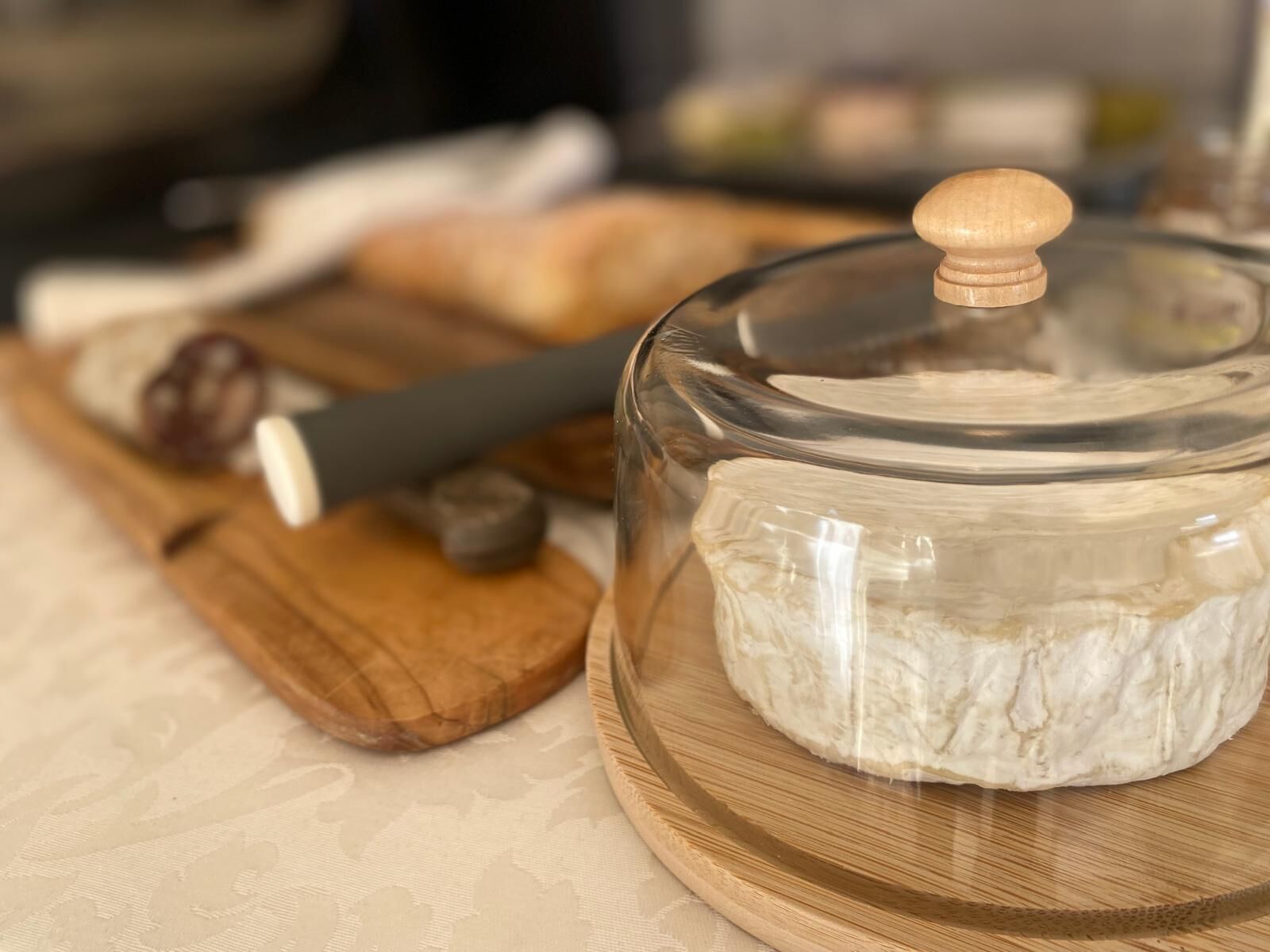 Un barattolo di vetro con coperchio in legno su un tagliere di legno.