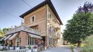 A two-story building with a balcony, a gravel driveway, and potted plants. - Duchessa Margherita (Vicoforte)