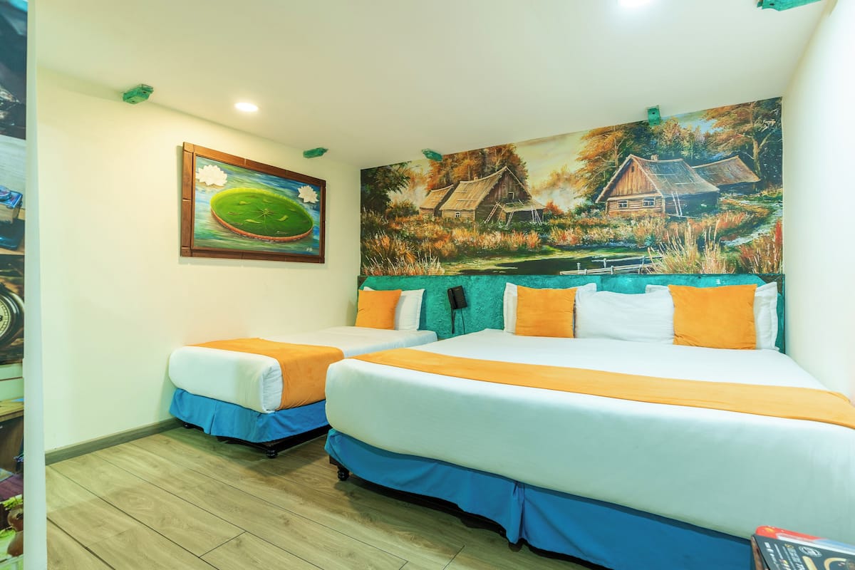 Une chambre d’hôtel avec deux lits, une fresque murale et une horloge au mur.