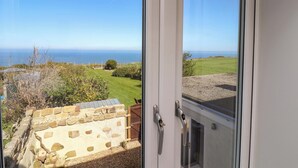 A room with a view of the sea, a stone wall, and a wooden gate. - Voebroch (Whitby)