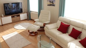 Una sala de estar moderna con un televisor de pantalla plana, un sofá blanco con cojines rojos, un sillón blanco y una mesa de centro de vidrio.