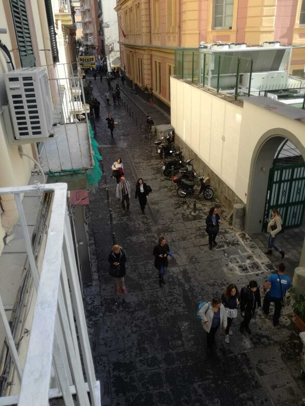 A narrow street with pedestrians, parked scooters, and buildings with balconies. - Residence Santa Teresa a Chiaia (Naples)