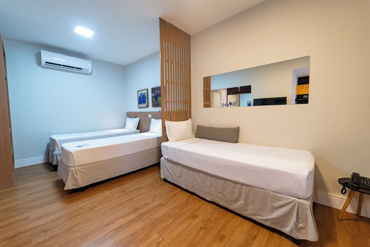Quarto, 3 camas de solteiro | Frigobar, cofres nos quartos, escrivaninha