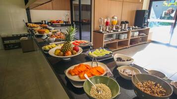 Een buffet met verschillende soorten fruit, groenten en drankjes.