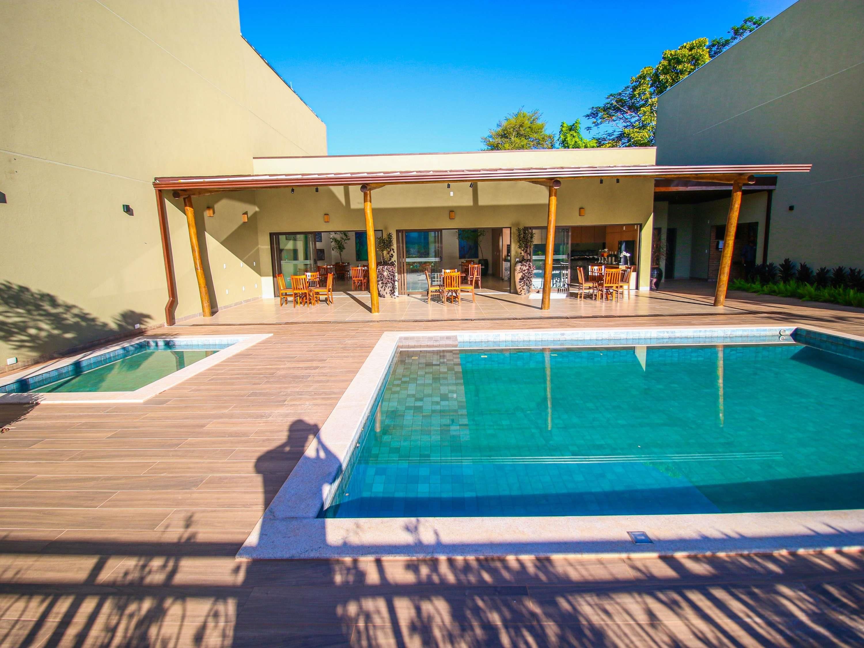 A swimming pool with a wooden deck and outdoor seating area.