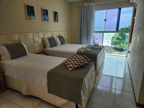 Een hotelkamer met twee bedden, een groot raam met uitzicht en een balkon.