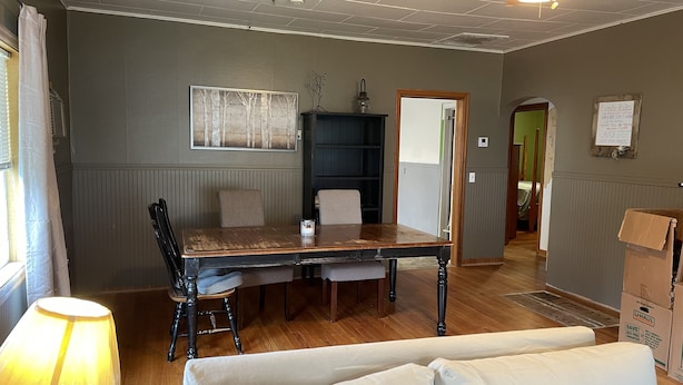 A dining area with a wooden table and chairs, a lamp, a bookshelf, and a couch. - Cozy 2+bed/1bath in quiet neighborhood (Pomeroy)