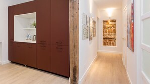 Un couloir avec une armoire marron, un mur d’accent en bois et des œuvres d’art encadrées accrochées aux murs.