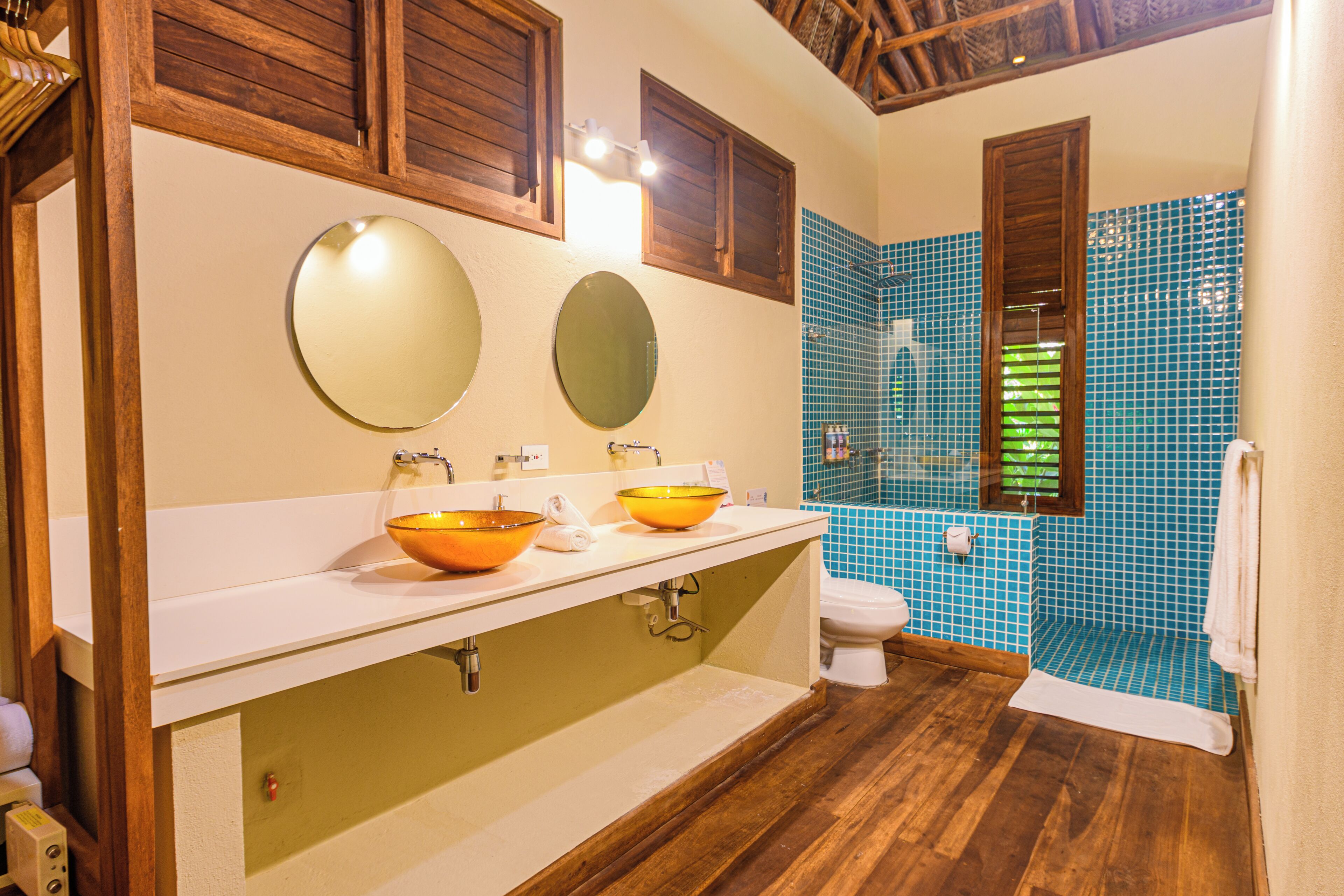 A bathroom with two sinks, a toilet, and a shower area.