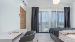 A modern hotel room with a bed, a desk, and a chair. - Charming 4BR Villa with Private Pool and Nature Views (Vabriga)