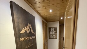 Un corridoio con soffitto in legno, una targa bianco e nero a sinistra e una citazione motivazionale a destra.