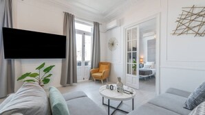 Een moderne woonkamer met een grijze bank, een ronde salontafel en een gele fauteuil.