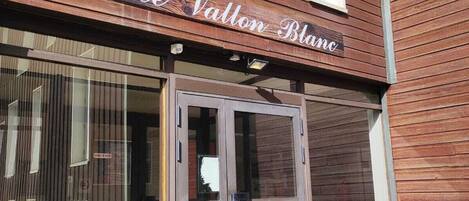 Un edificio de madera con un letrero que dice "Le Vallon Blanc".