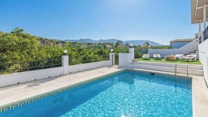 Une piscine avec vue sur les montagnes et la verdure.