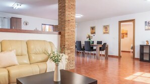 Un salon comprenant un canapé, une table basse et un coin repas avec des chaises et une table.