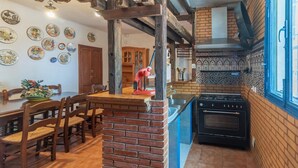 A kitchen with a brick column, a stove, and a sink.