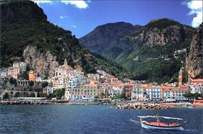A coastal town with colorful buildings, a prominent church, and a boat in the foreground.