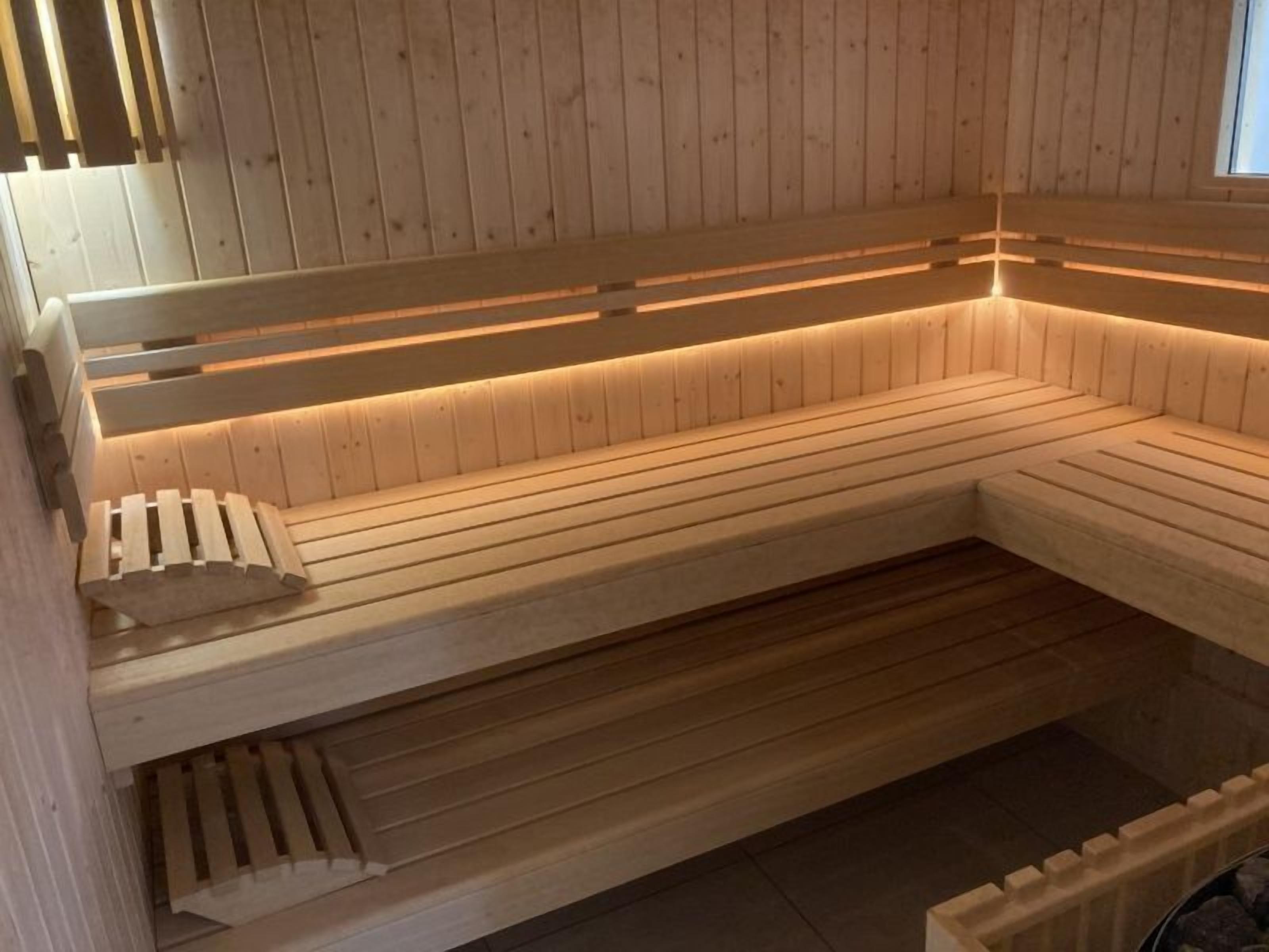 Een houten sauna met banken, inclusief een bank met rugleuning.