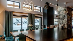 A modern kitchen with a large island, stone accents, and a view of snowy mountains.
