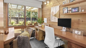 Work in comfort with a spacious desk, comfortable chair, and serene garden views.