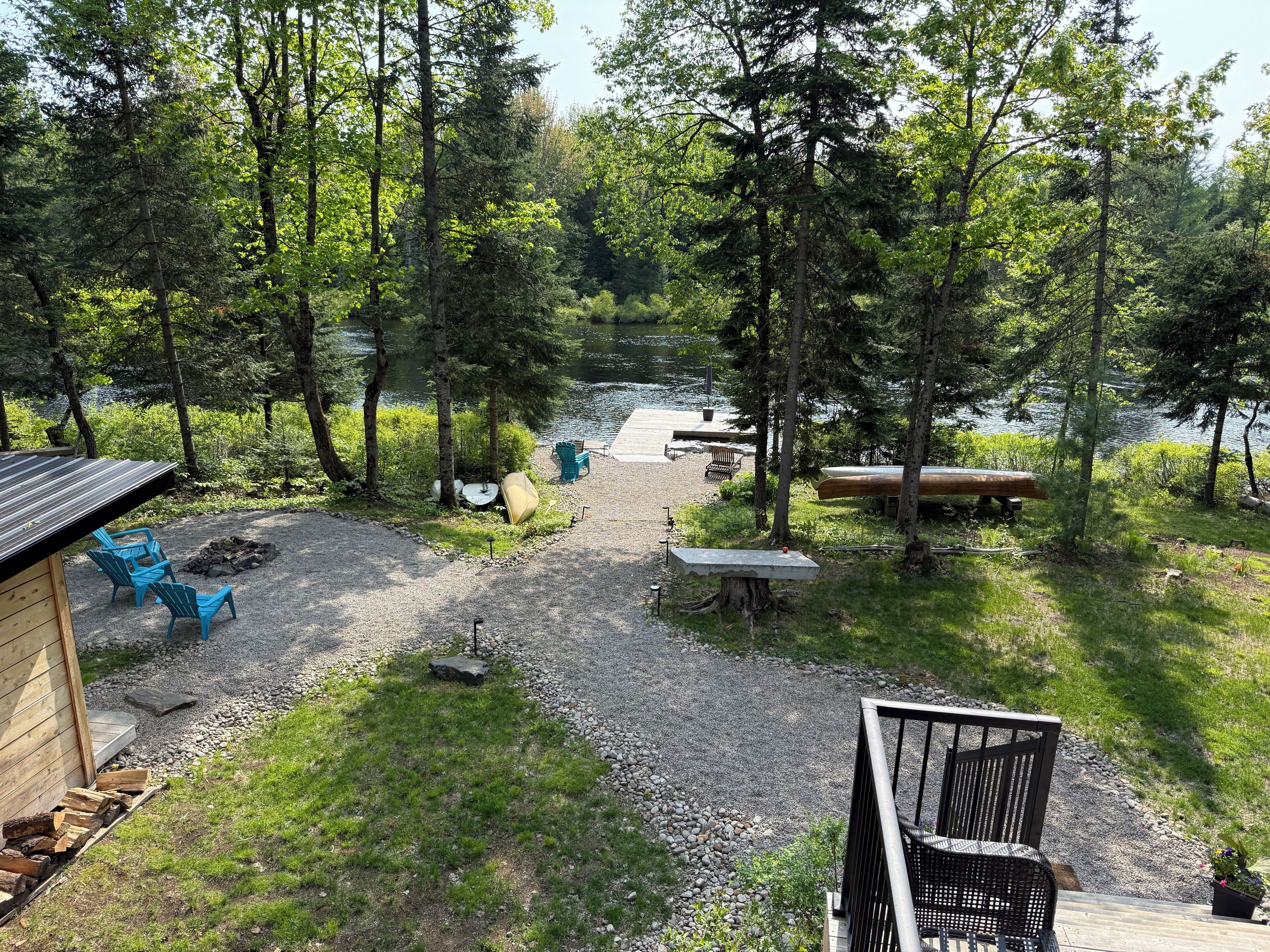 A lakeside cabin with outdoor seating, a fire pit, and a dock extending into the water.