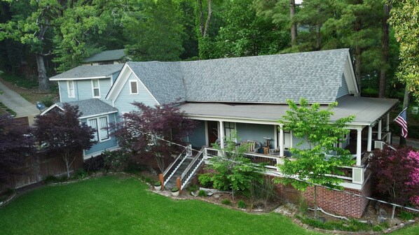 A two-story house with a porch, a brick section, and a satellite dish. - Historic Home - Walk to Downtown I Hot Tub (Hot Springs)