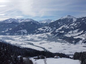 Une vue panoramique d’un paysage montagneux enneigé, avec une vallée en contrebas.