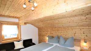 A wooden-paneled room with a bed, a sofa, and a window. - Lovely apartment in villa for 10 guests with WIFI, TV, balcony and pets allowed (Hart Im Zillertal)