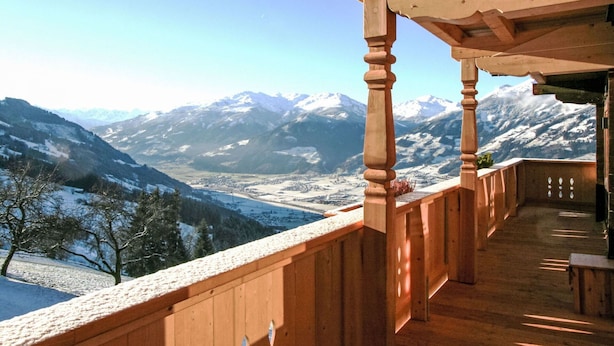 A wooden balcony with a view of snow-covered mountains and a valley below. - Lovely apartment in villa for 10 guests with WIFI, TV, balcony and pets allowed (Hart Im Zillertal)